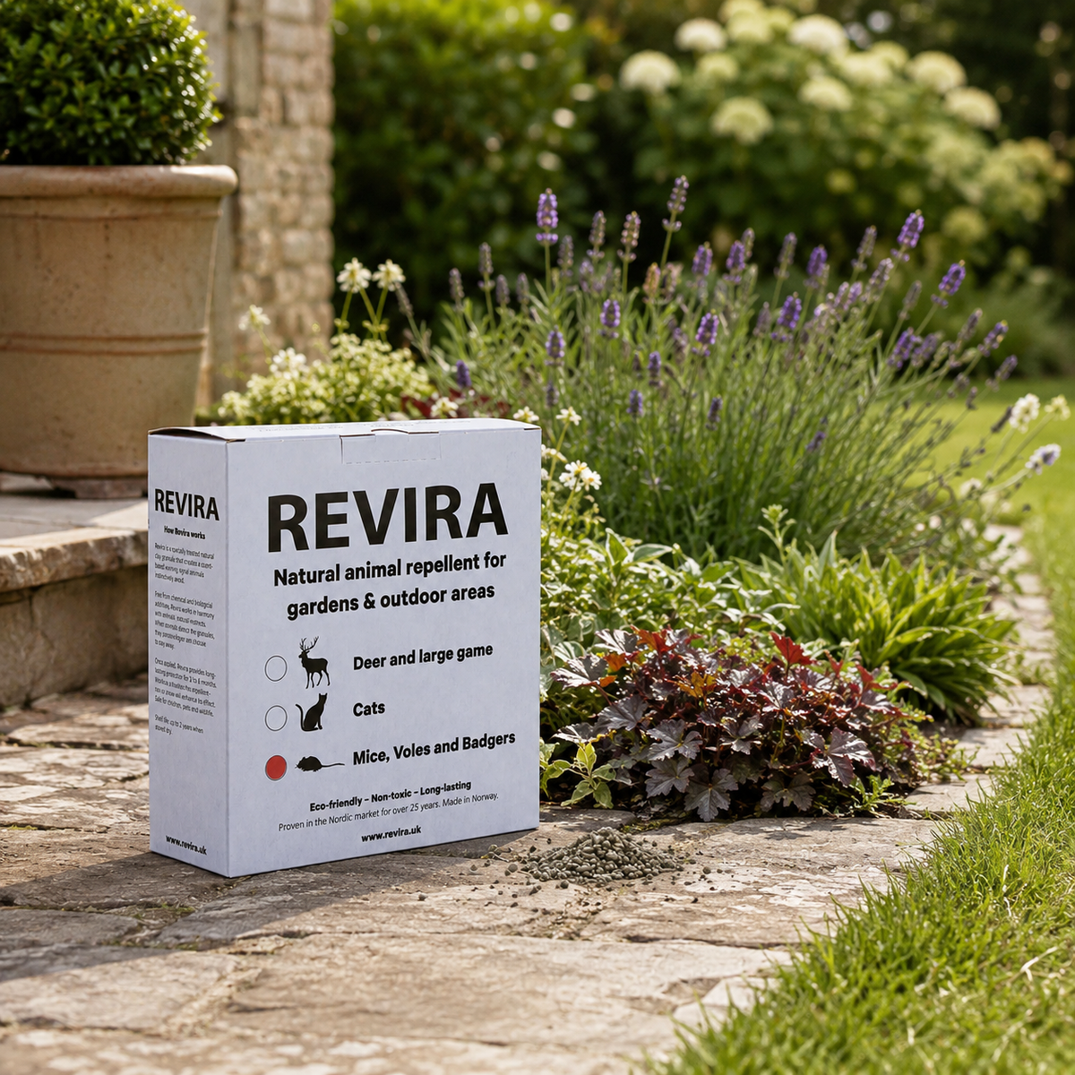 [ENG] Natural animal repellent for mice, voles and badgers box sits on a stone path in a garden setting, with grass, plants, and flowers in the background.